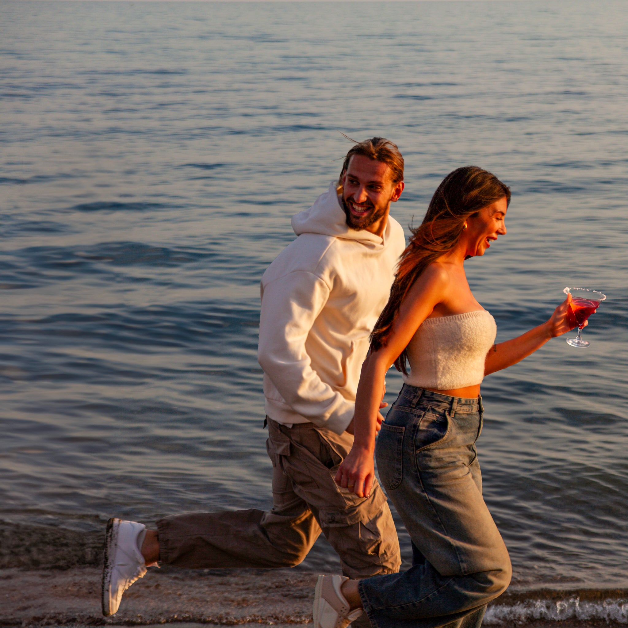 fun couple on a beach date at sunset