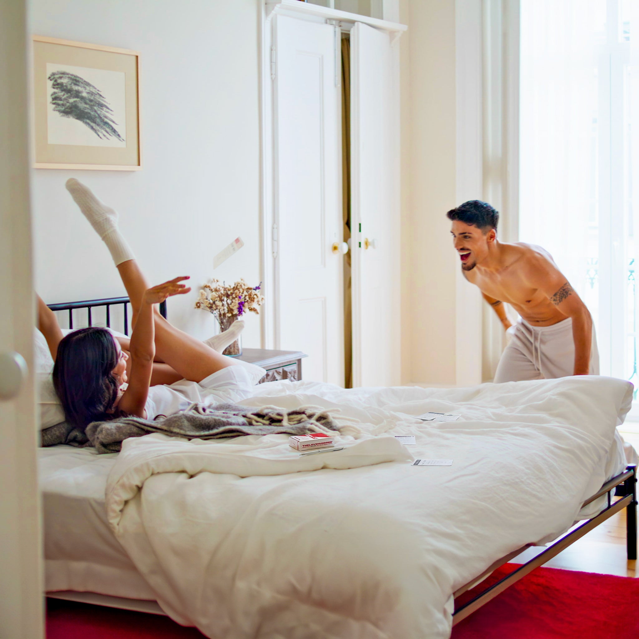 playful couple choosing a date idea in the bedroom